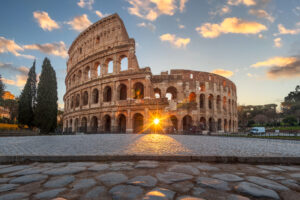 Rome, Italy at the Colosseum Amphitheater with the sunrise through the entranceway.