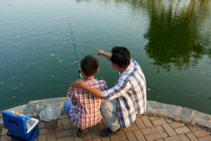 Father pointing where his son should throw the lines