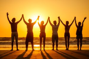 six health people in stand hatha position with hand up raced and breath full chest in Goa India beach at sunset .